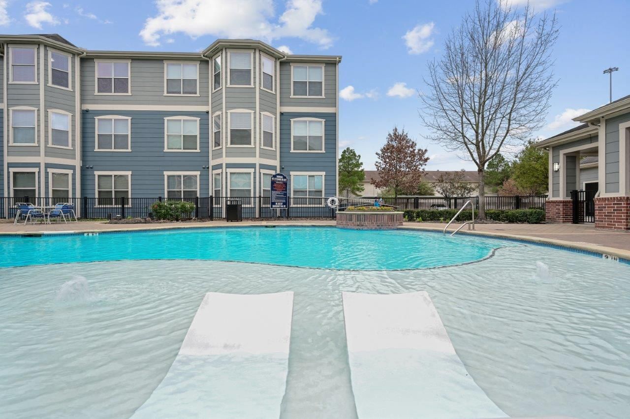There is a large swimming pool in front of a building.