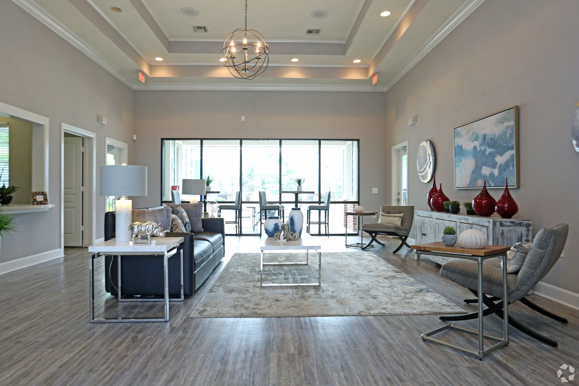 A living room with a couch , chairs , tables and a chandelier.