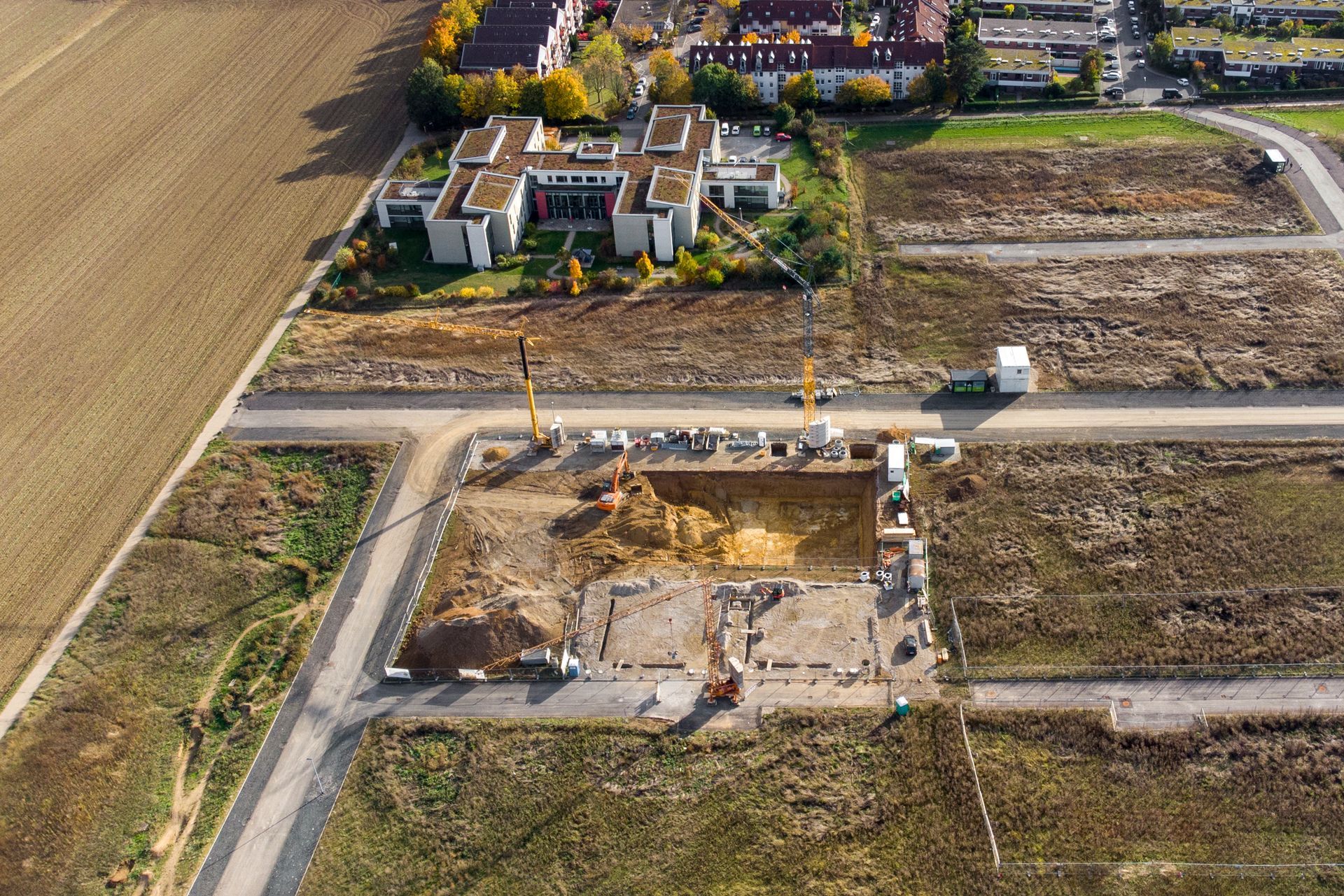 An aerial view of a construction site with a large building in the background.