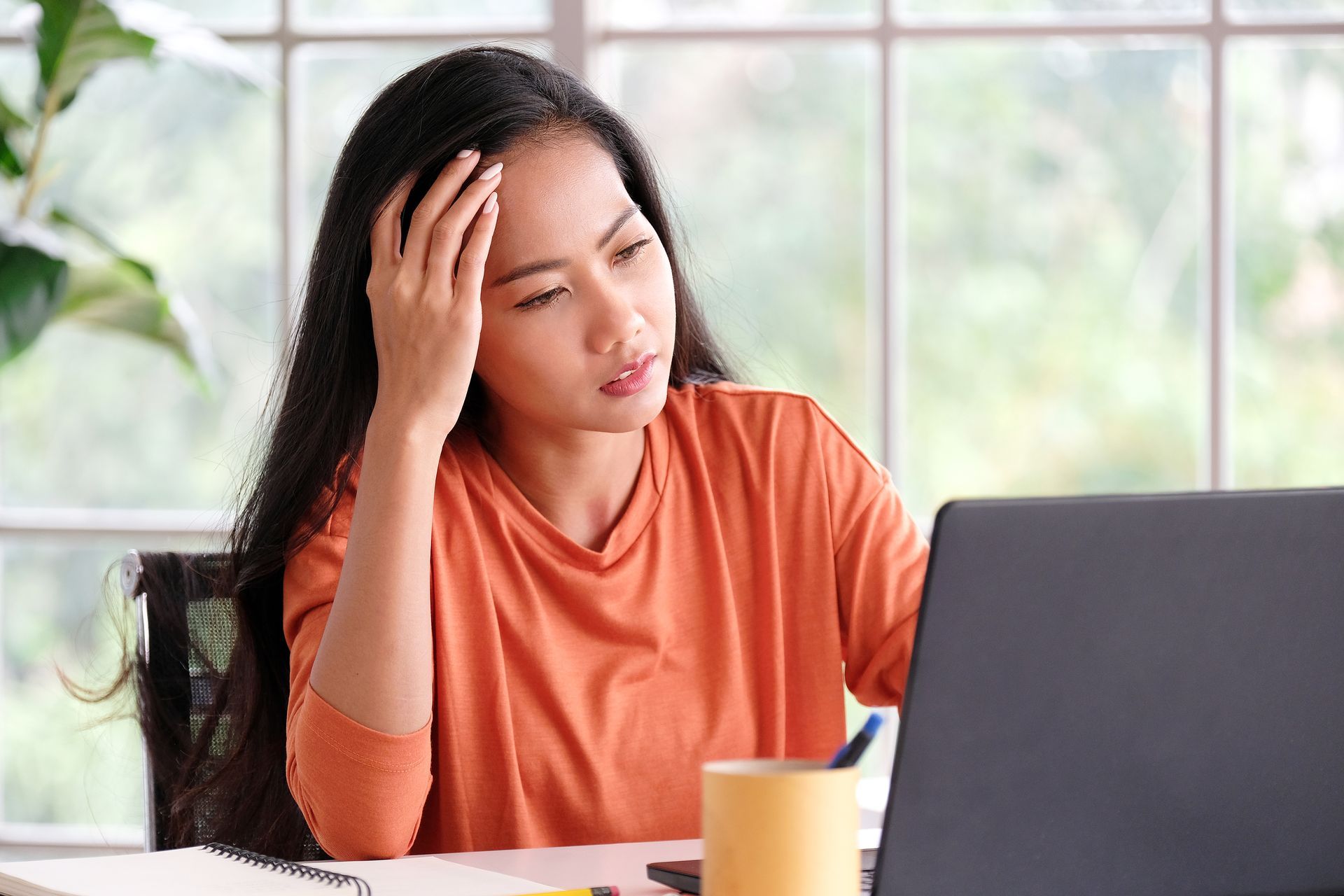 Woman staring at her computer screen, trying to figure out how to implement SEO strategies