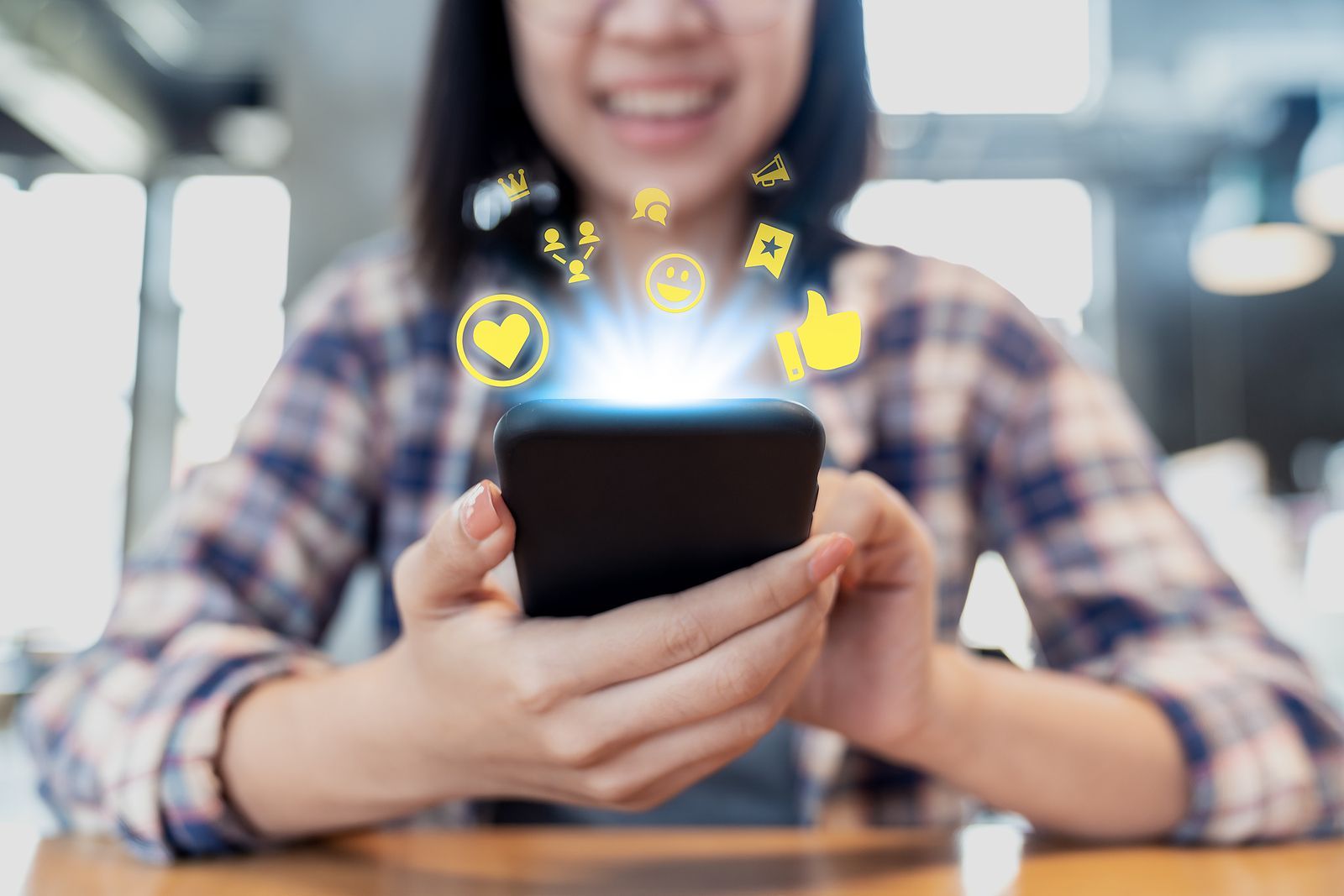 Woman holding phone with social media icons radiating outwards.