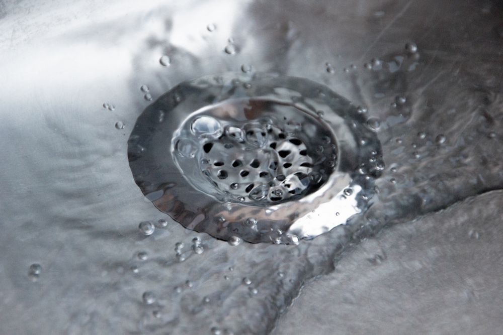 Water Flowing Down a Stainless Steel Sink Drain — Sunset Plumbing NT in Moil, NT