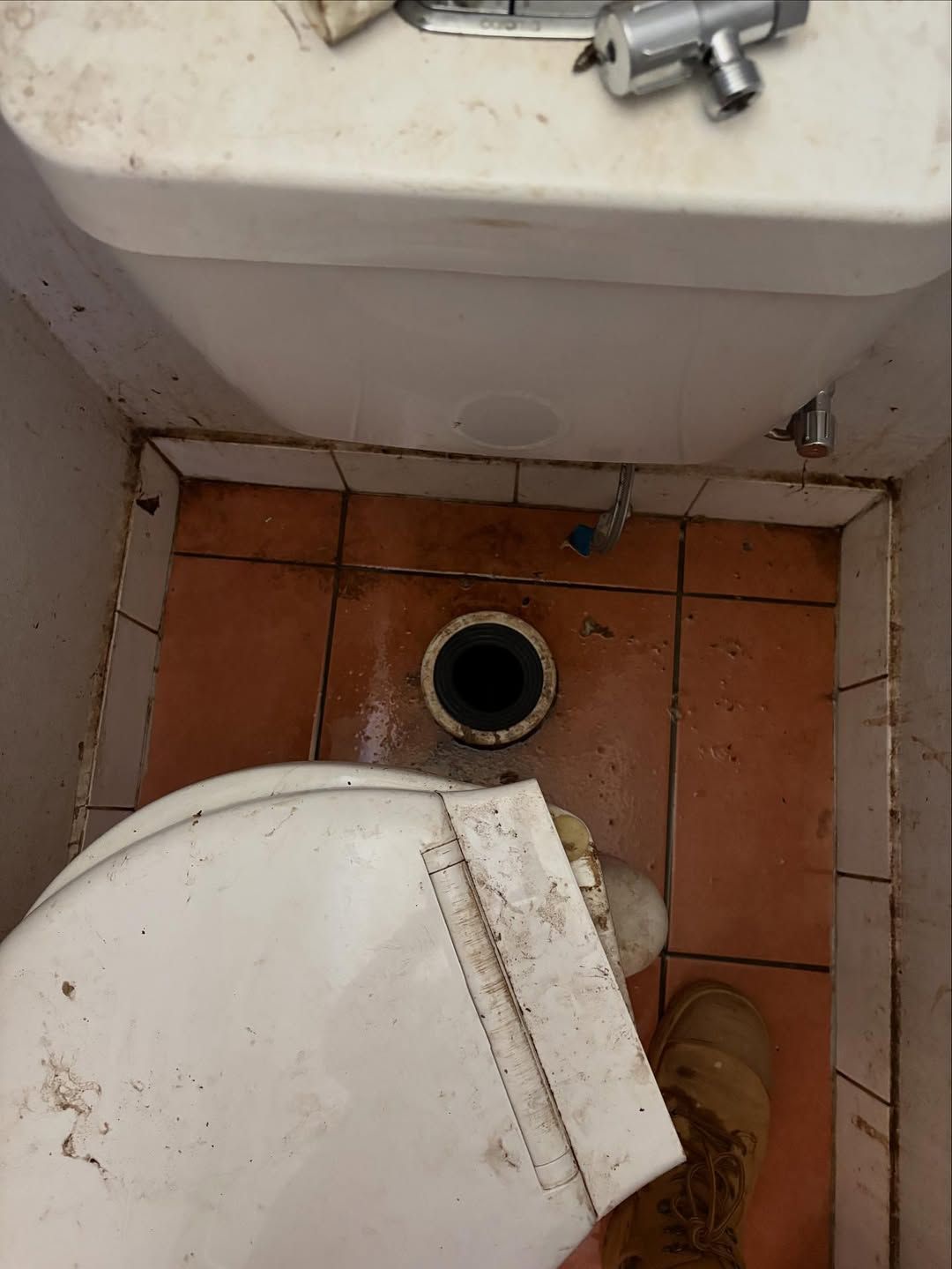 Toilet Removed, Exposing the Drain Hole. Brown Tiles — Sunset Plumbing NT in Moil, NT