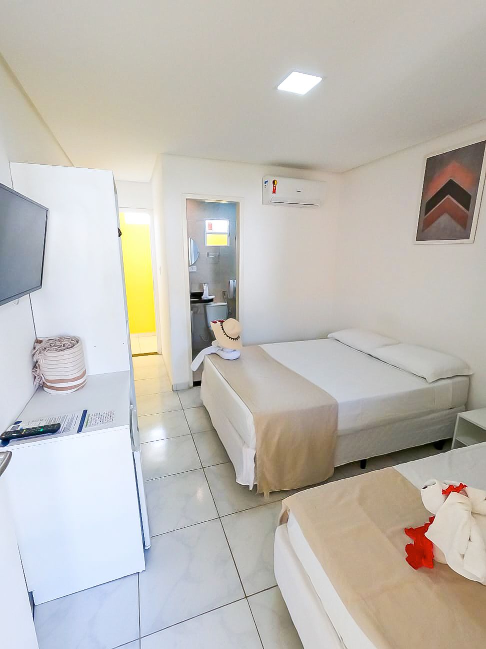 Um quarto de hotel com duas camas e uma TV de tela plana