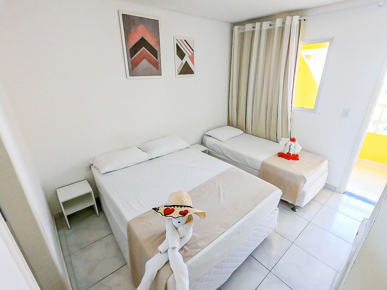 Um quarto de hotel com duas camas e uma mesa de cabeceira