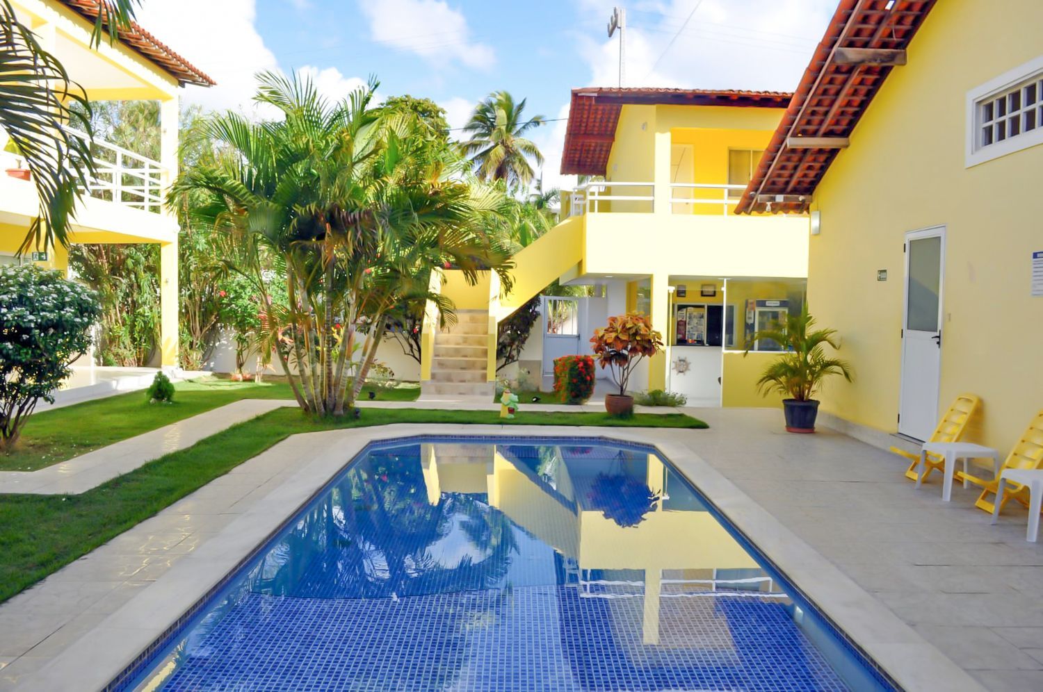 Uma grande piscina em frente a um prédio amarelo