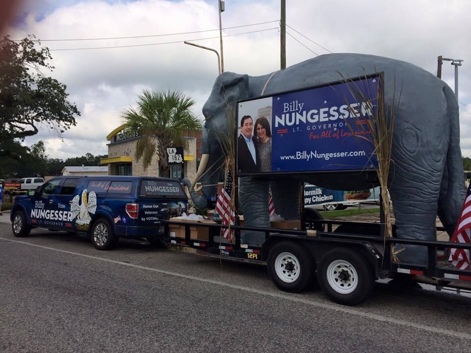 A large statue of an elephant is on a trailer.