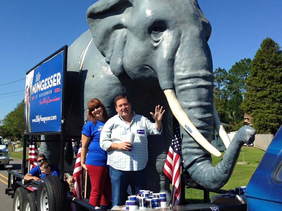 A man and woman are standing in front of an elephant statue