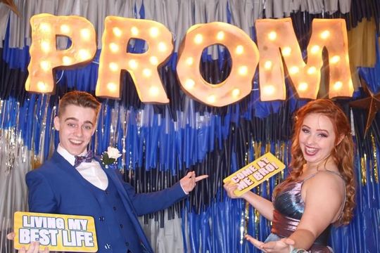 Prom night attendees striking poses and smiling at our photo booth.