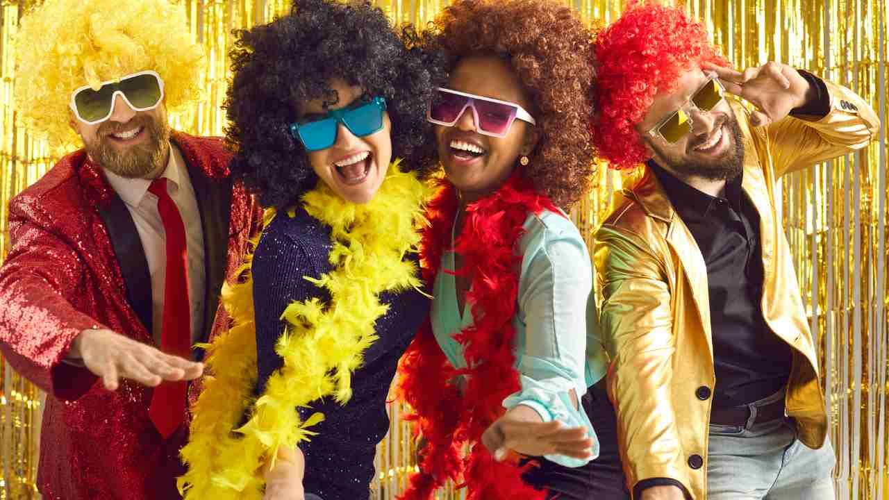 Four partygoers dressed in retro disco attire, striking a pose for a fun night out.