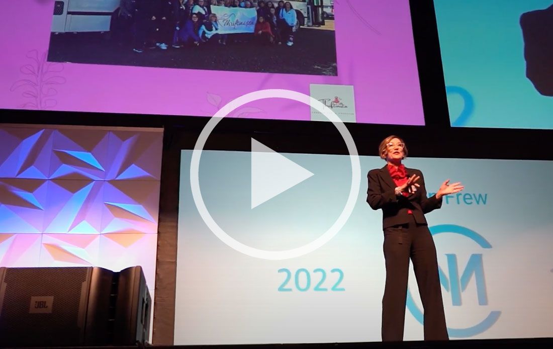 A man is giving a speech in front of a screen that says 2022