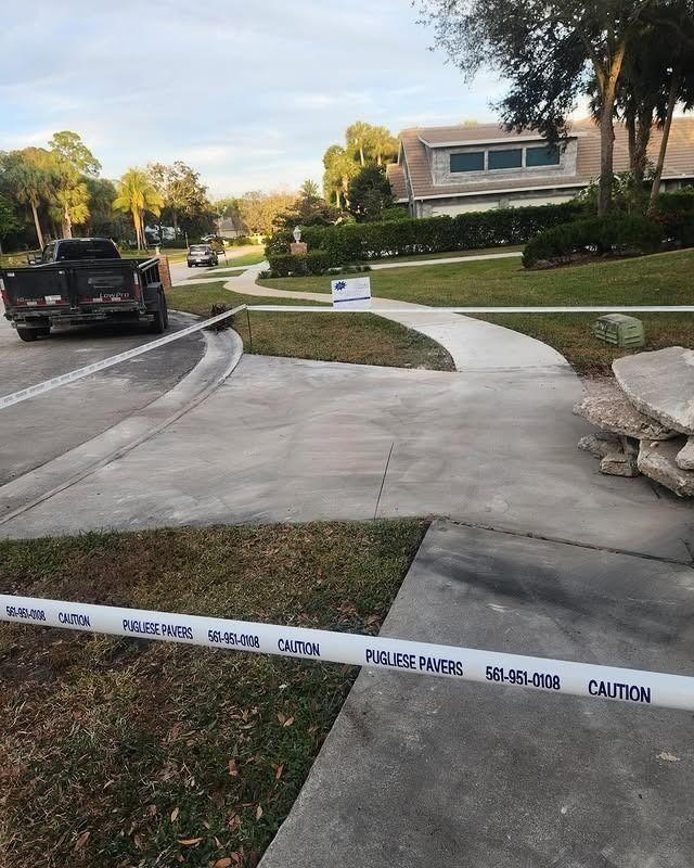 A residential scene features police tape cordoning off a driveway and sidewalk in front of a house with a parked truck.