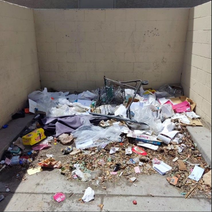 A dumpster filled with lots of trash including a bicycle