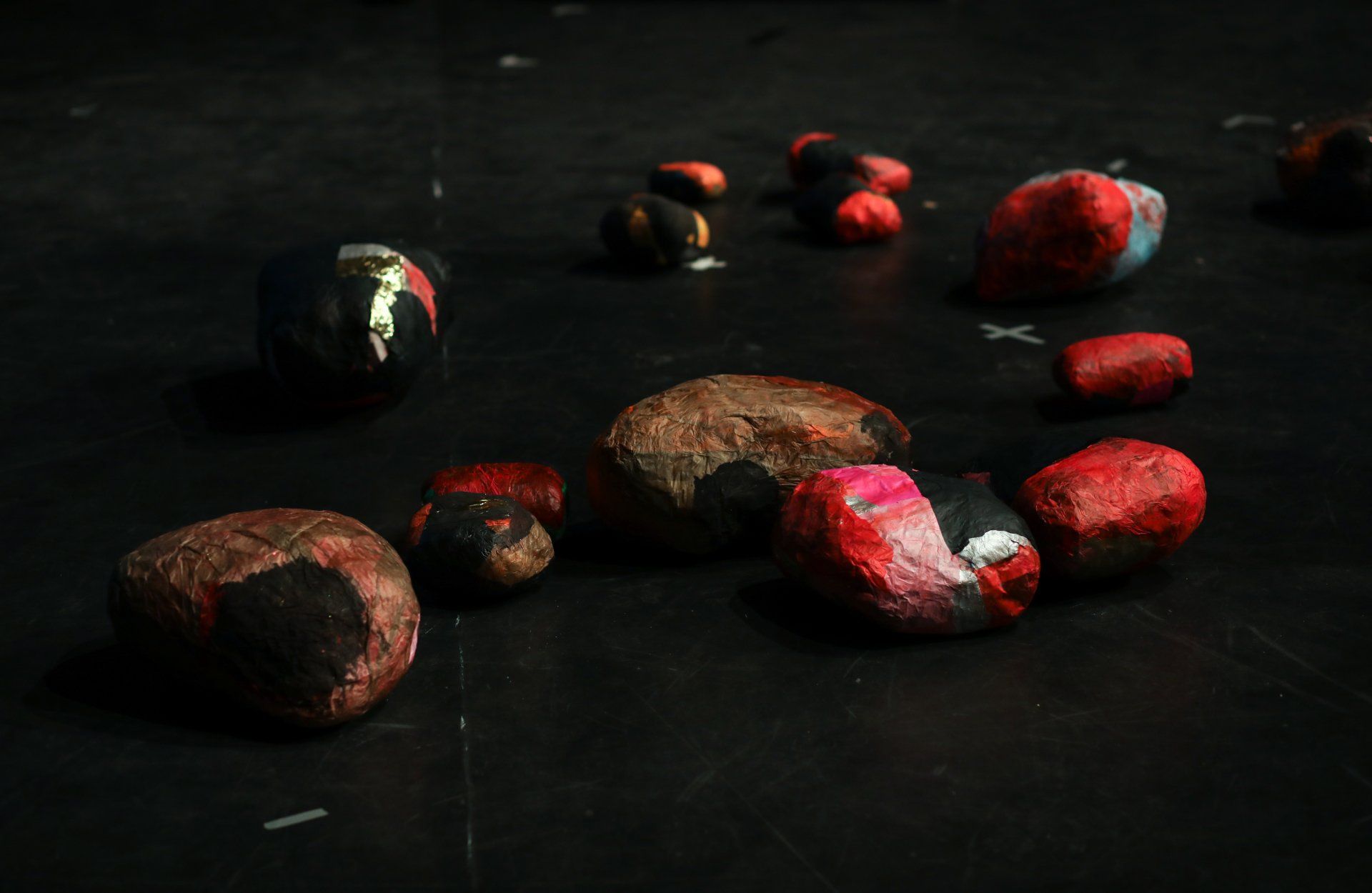 a group of painted rocks are sitting on a black surface .