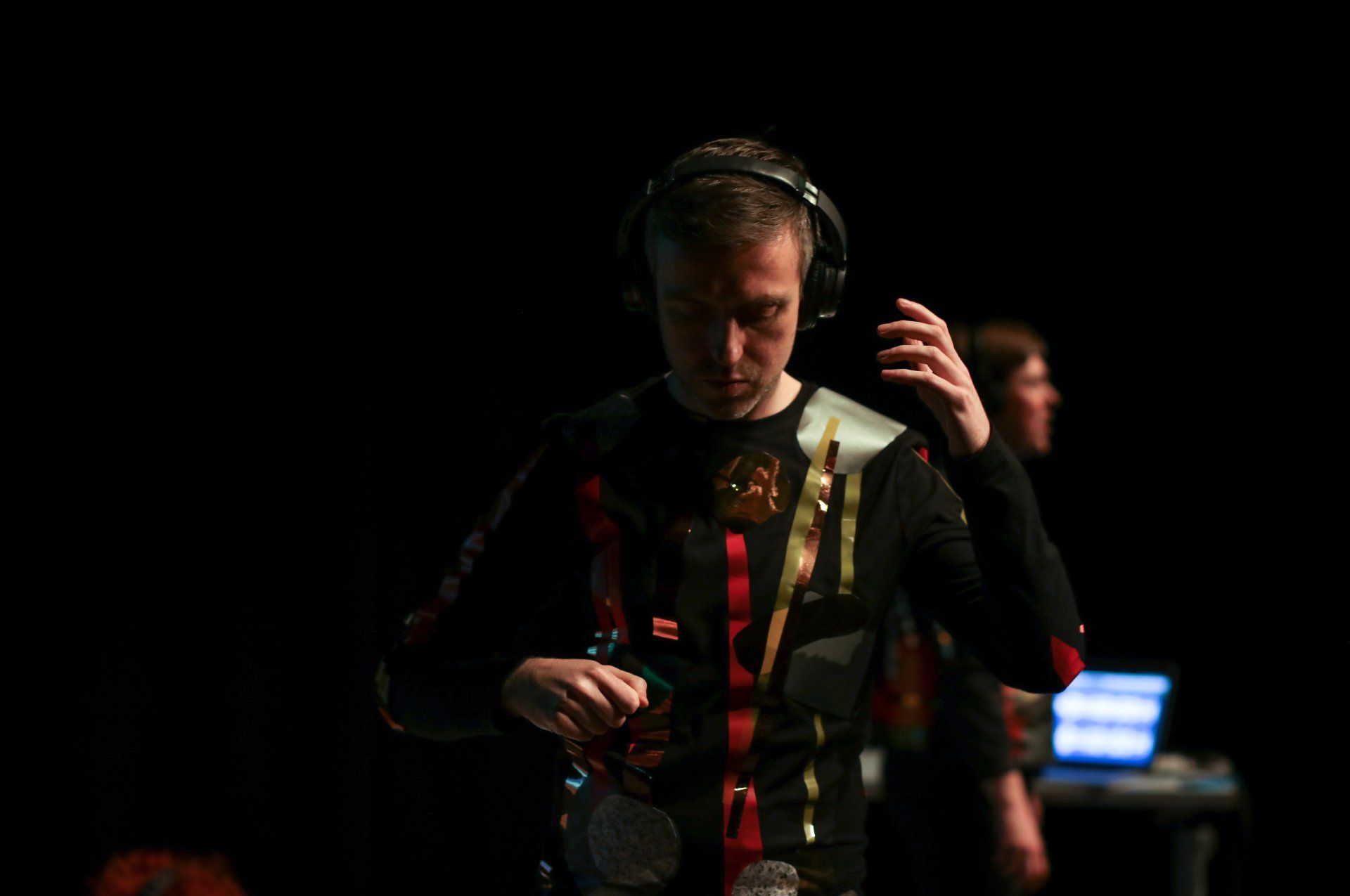 a man wearing headphones is standing in a dark room .