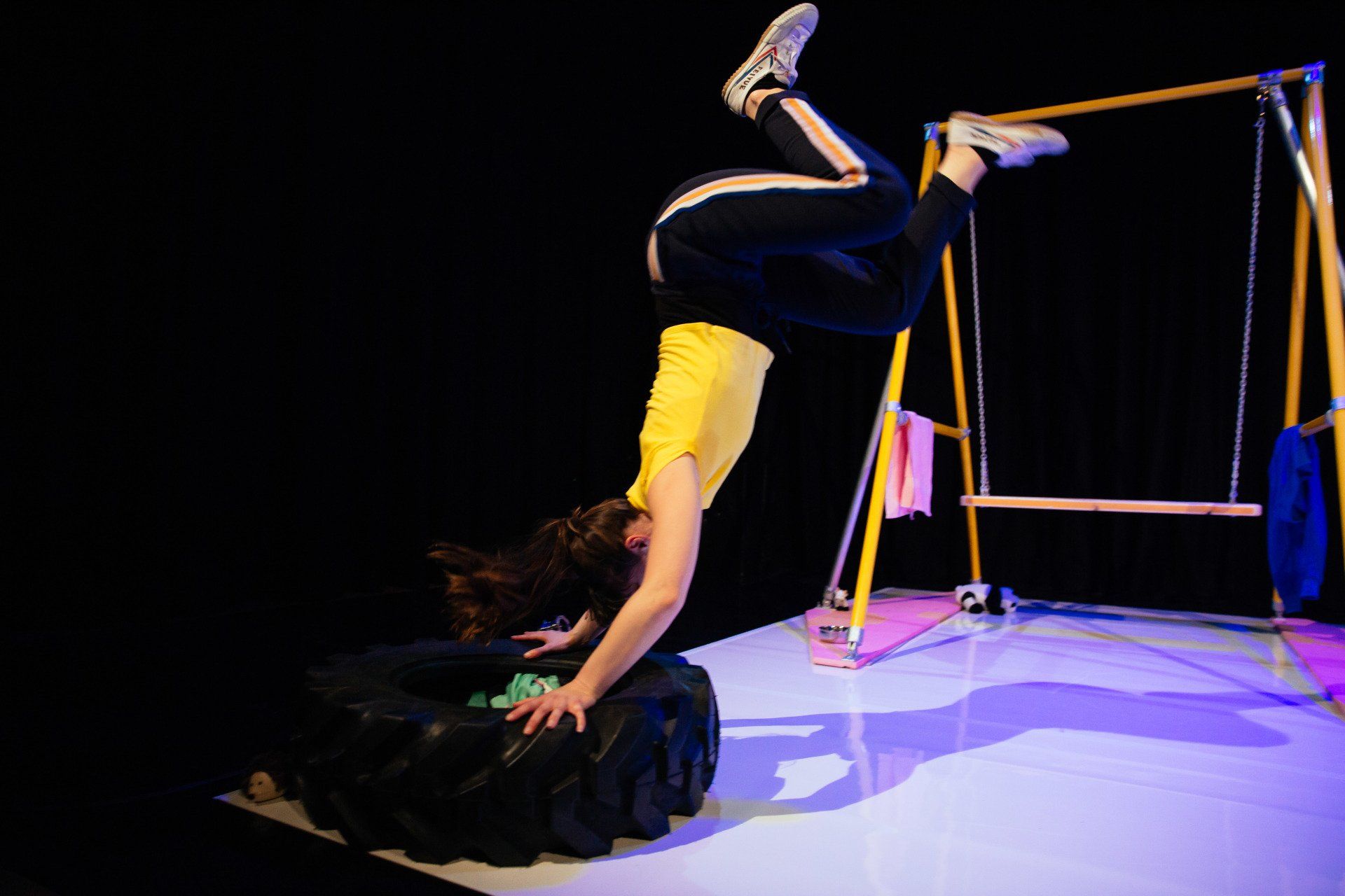 a person is doing a handstand on a tire on a stage .
