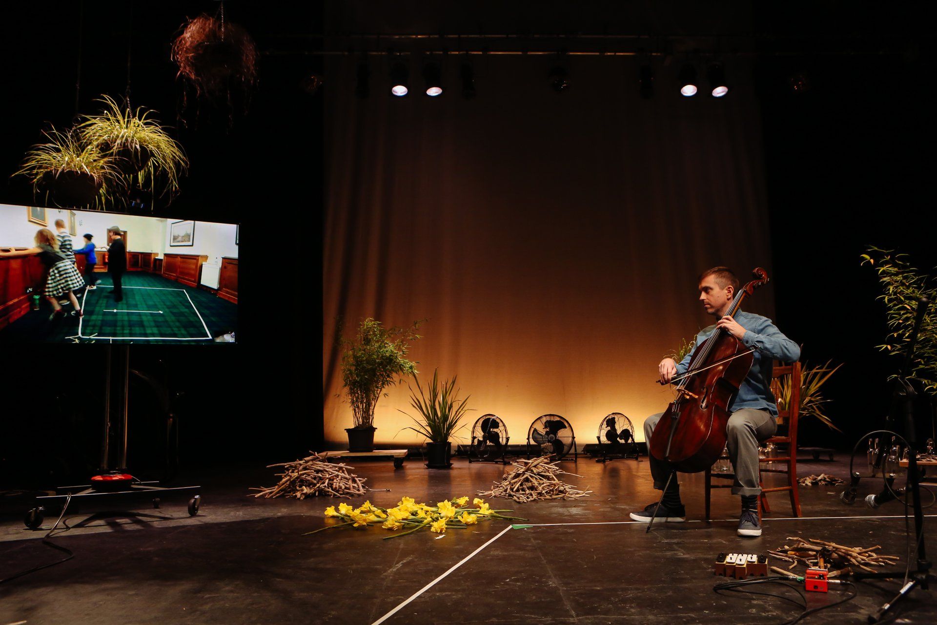 A man is playing a cello on a stage.