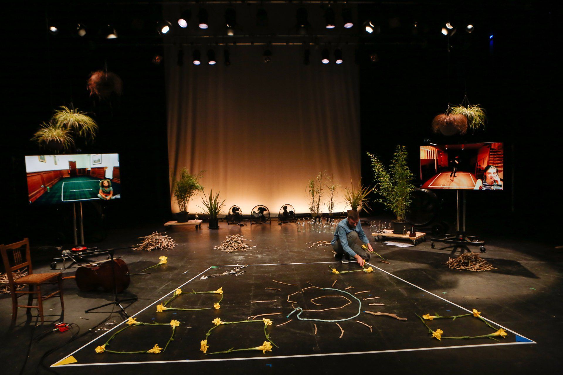 a man is drawing a sun on the floor of a stage .