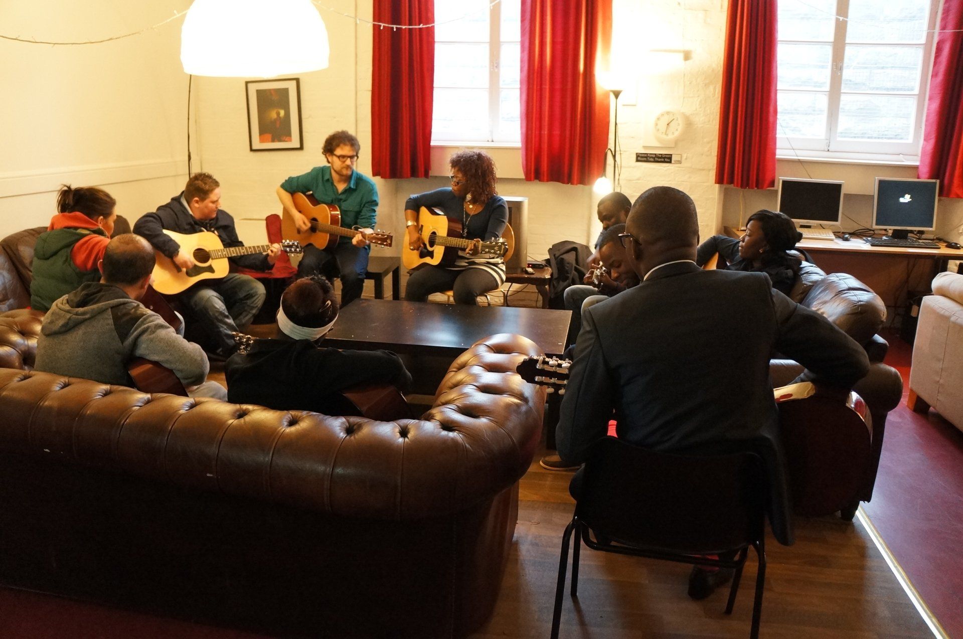 a group of people are playing guitars in a living room