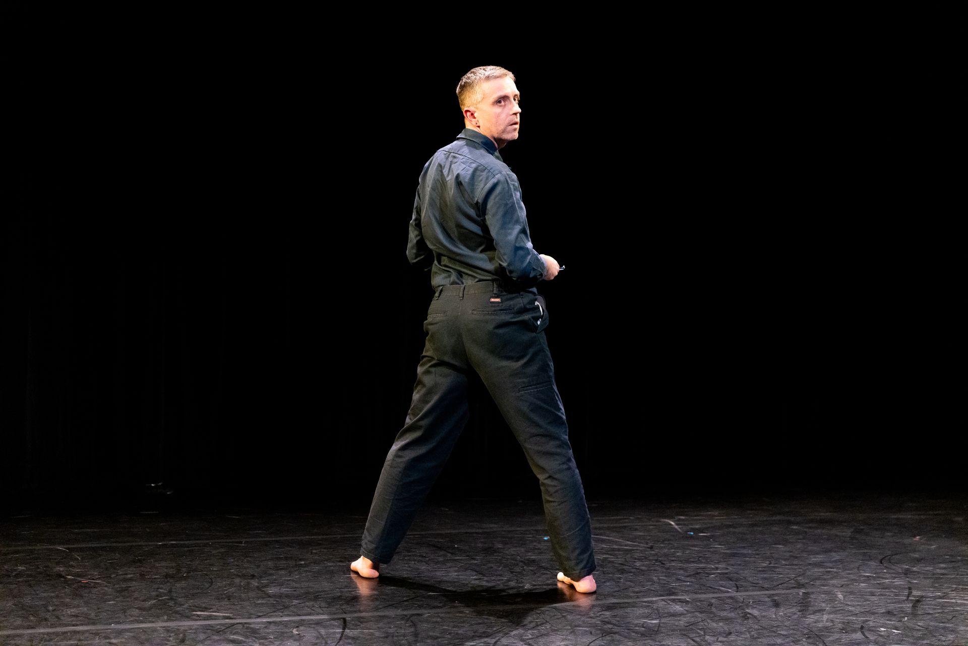 A man is standing on a stage in front of a black background.