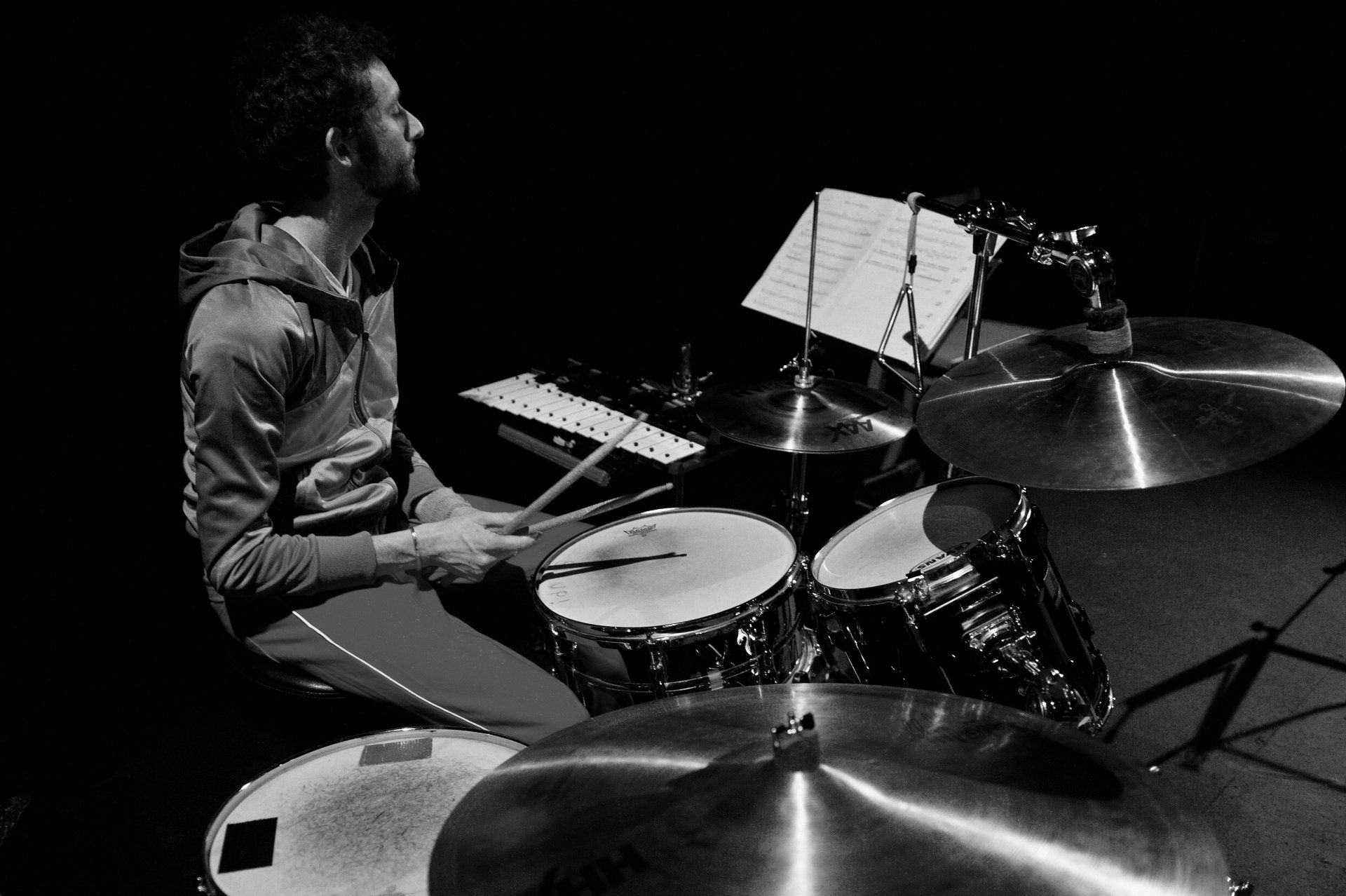a man is playing drums in a black and white photo .