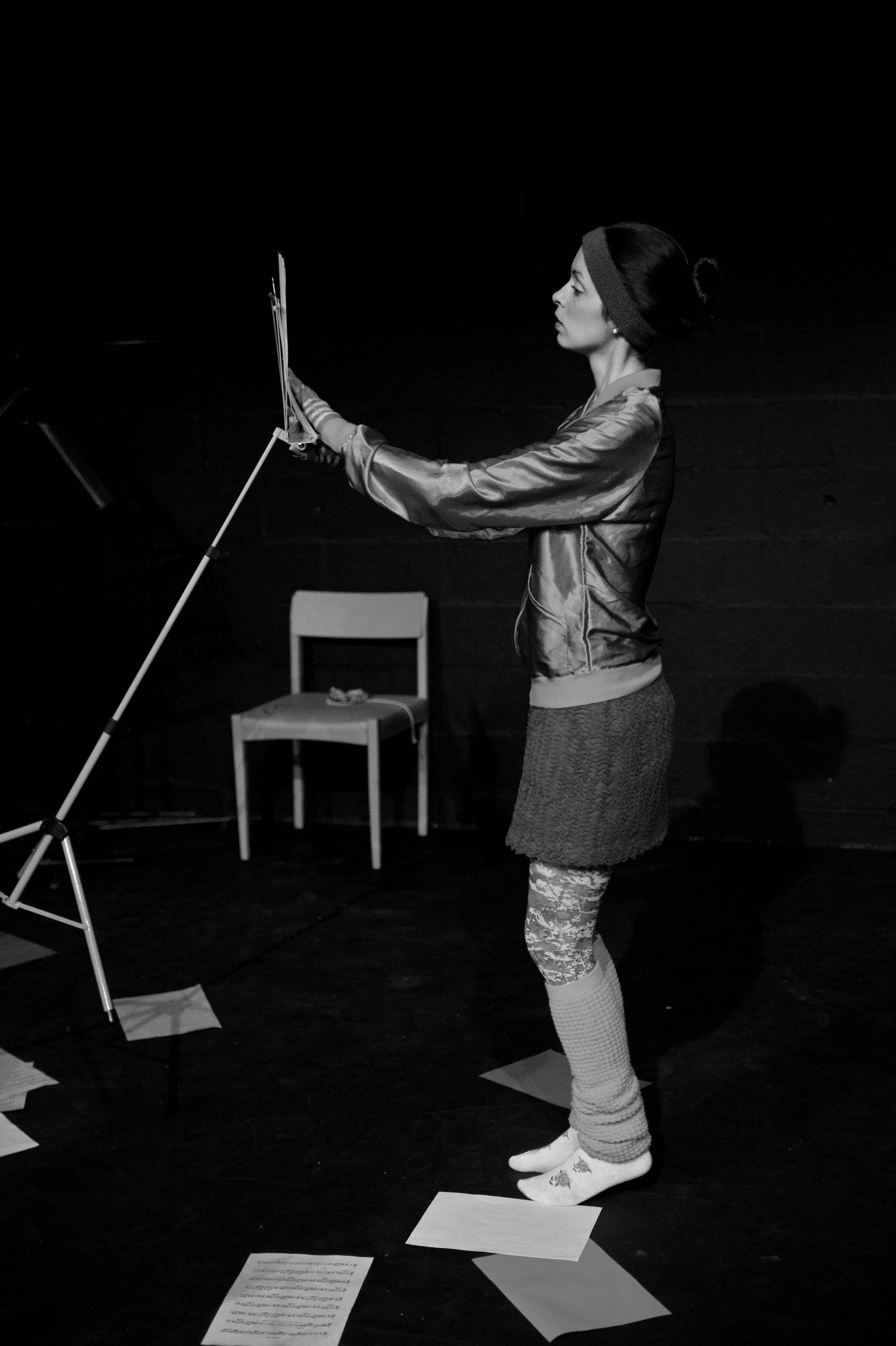 a woman is standing on a stage holding a piece of paper .