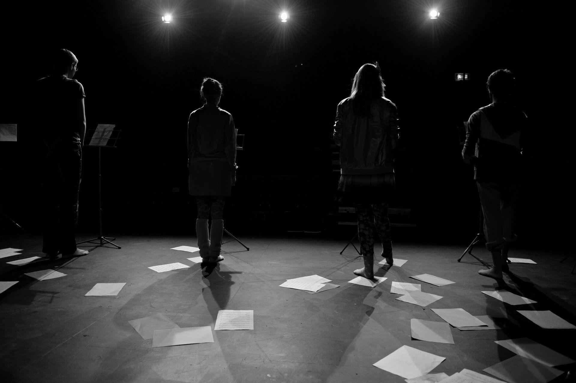a group of people standing on a stage with papers on the floor