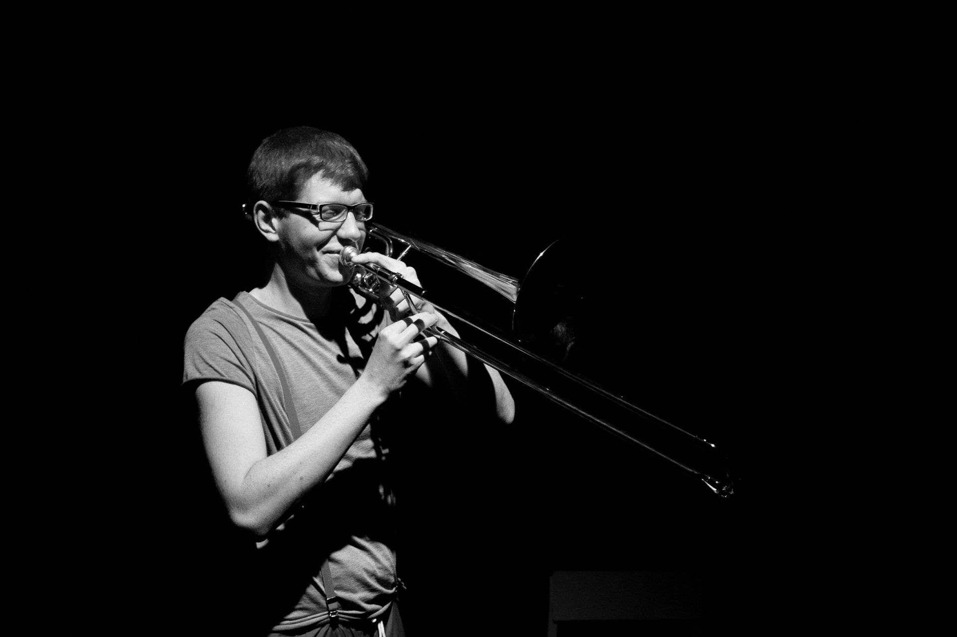 a man is playing a trombone in a black and white photo .