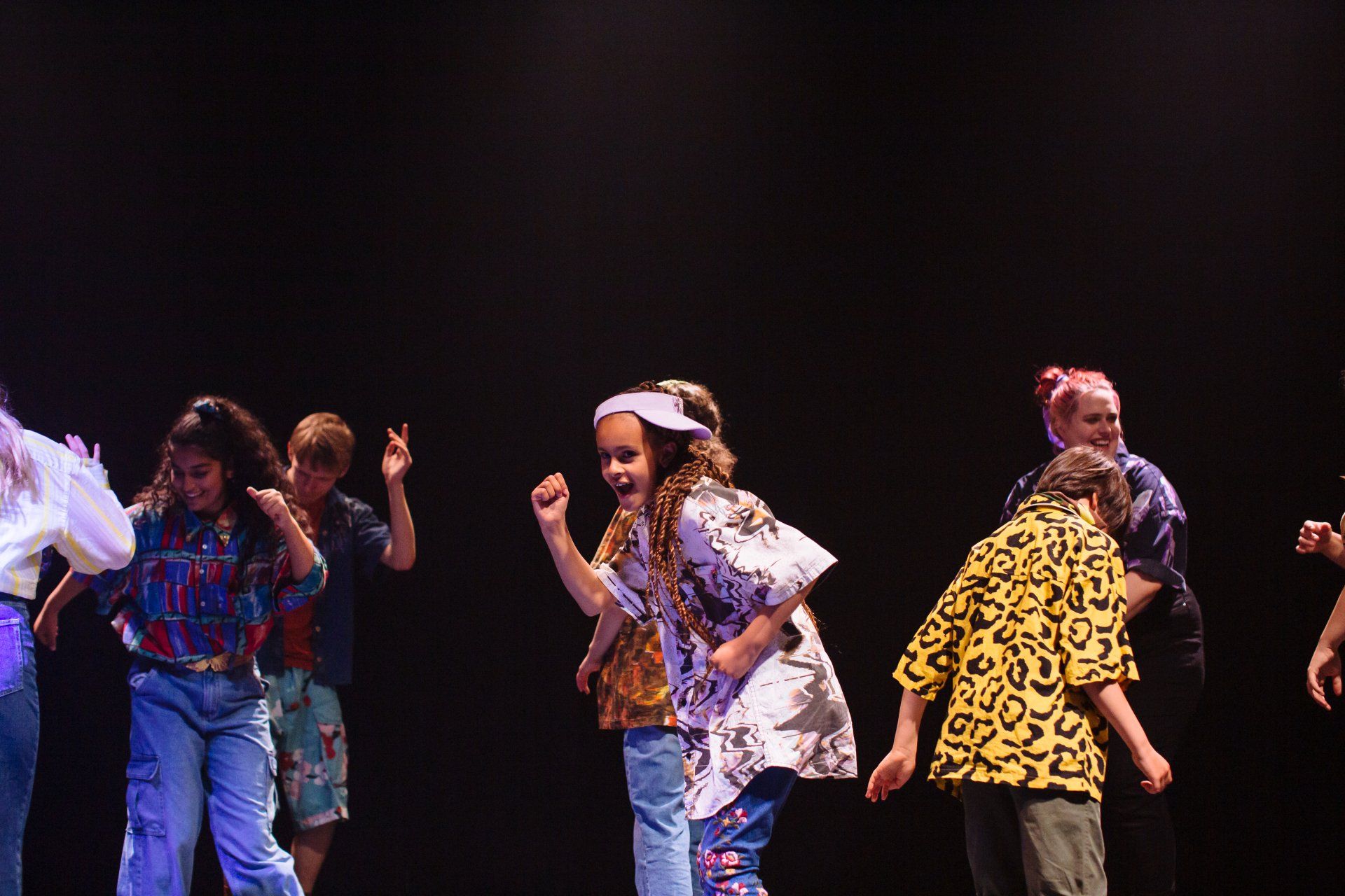 a group of young people are dancing on a stage .