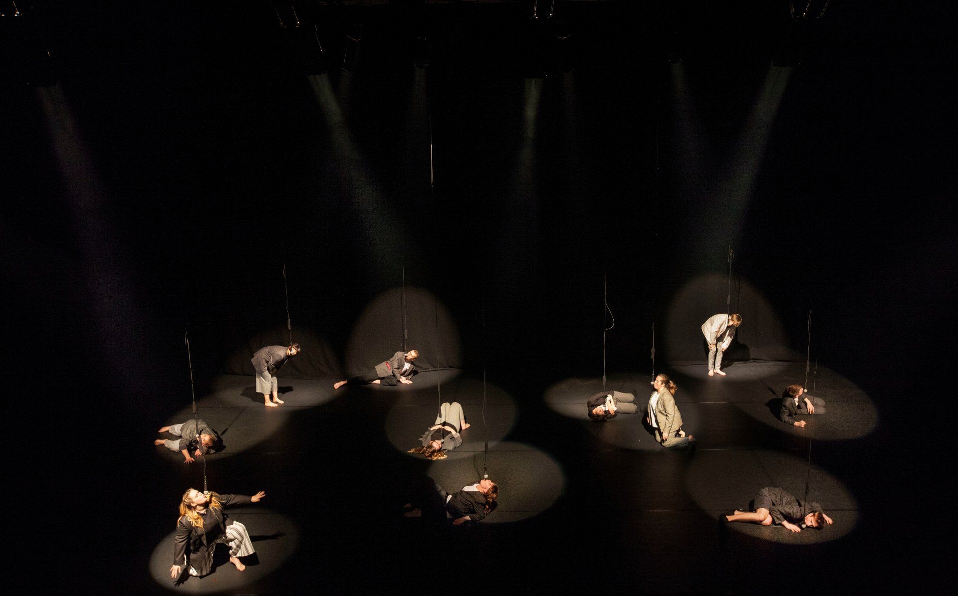 A group of people are dancing on a stage in a dark room.