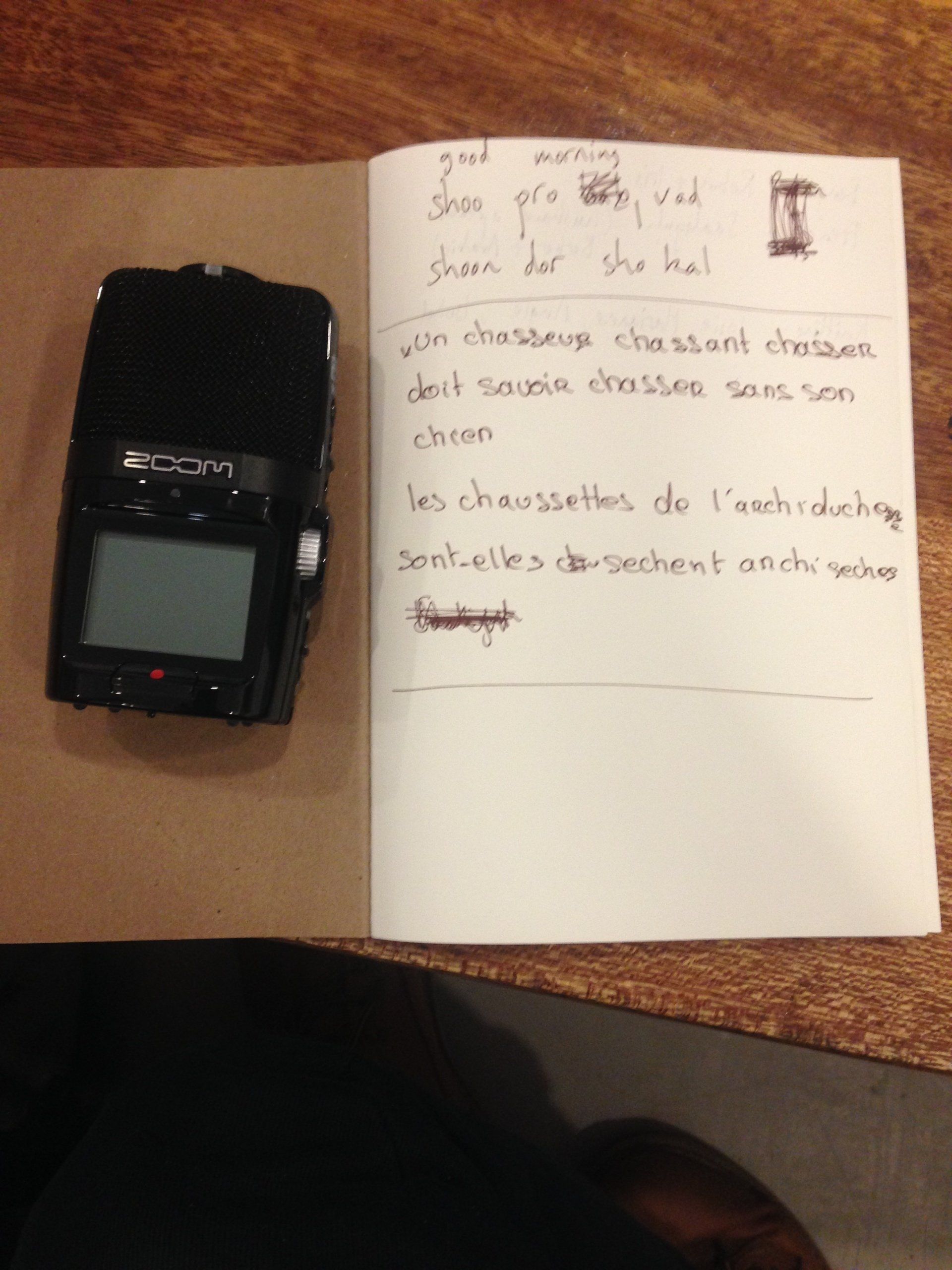 An audio recorder is sitting on top of a notebook.