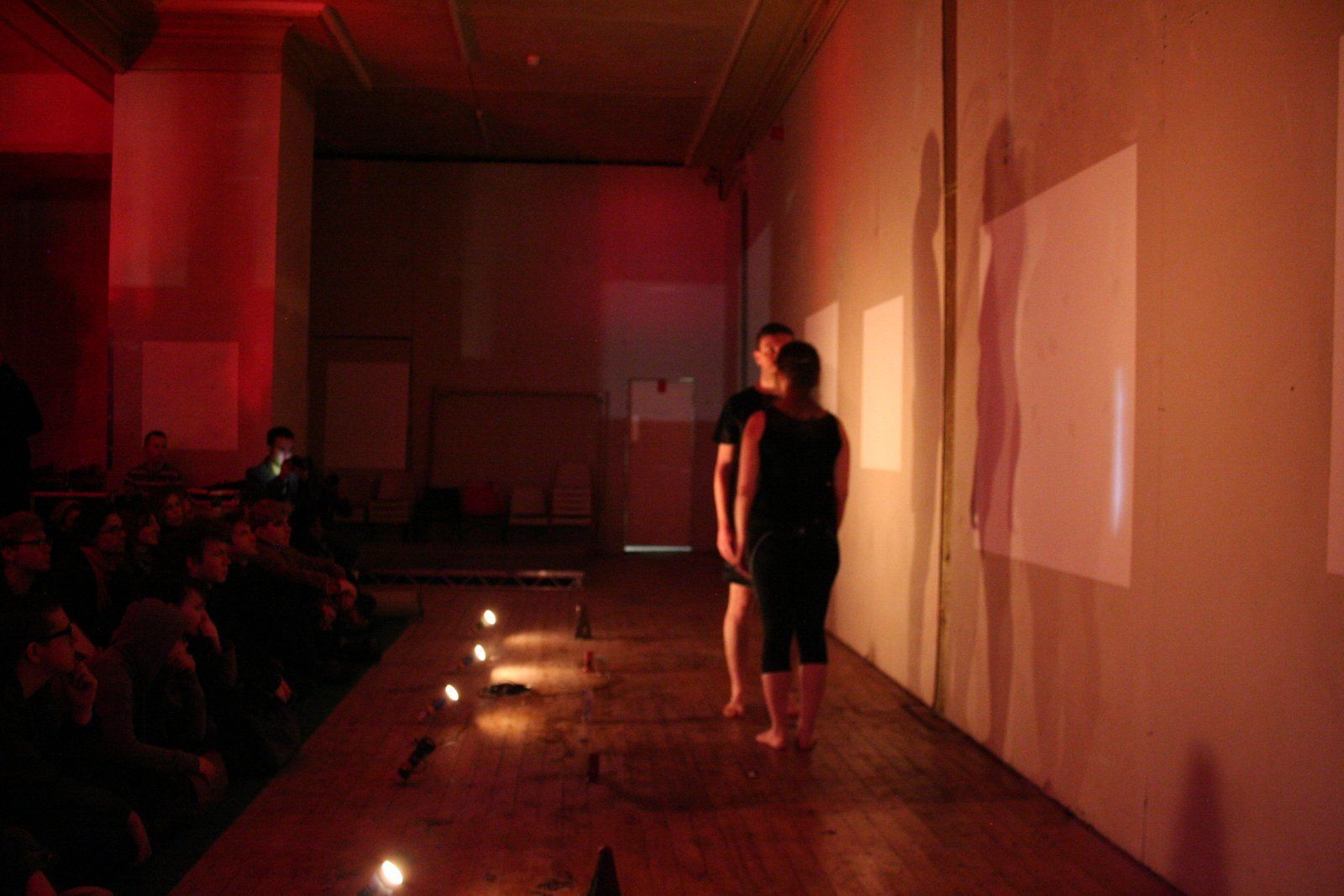 two people are standing on a stage in a dark room .