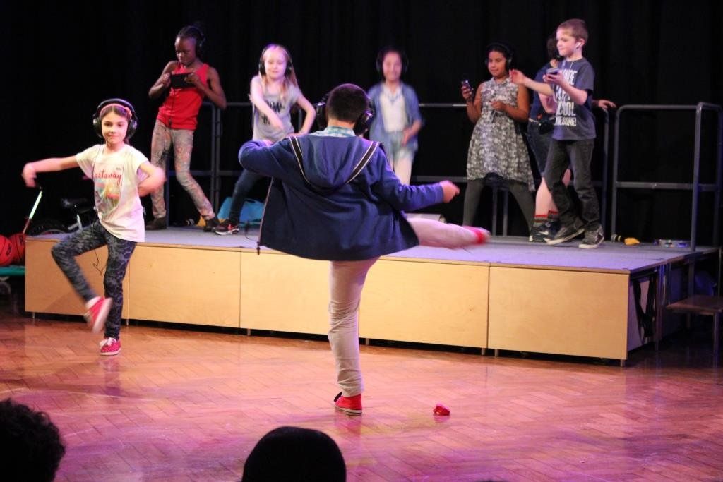 a group of children are dancing on a stage .