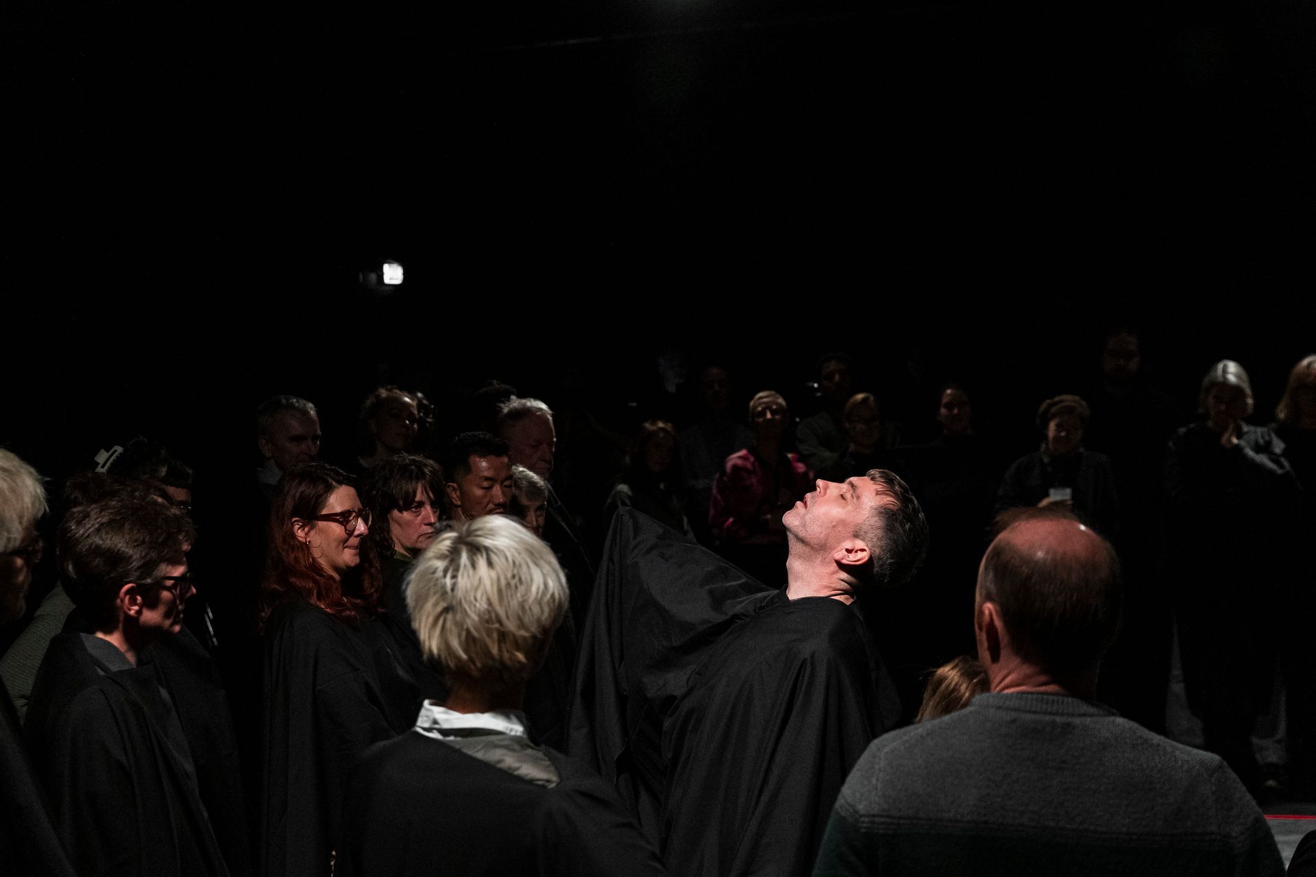 A group of people are standing in a dark room.