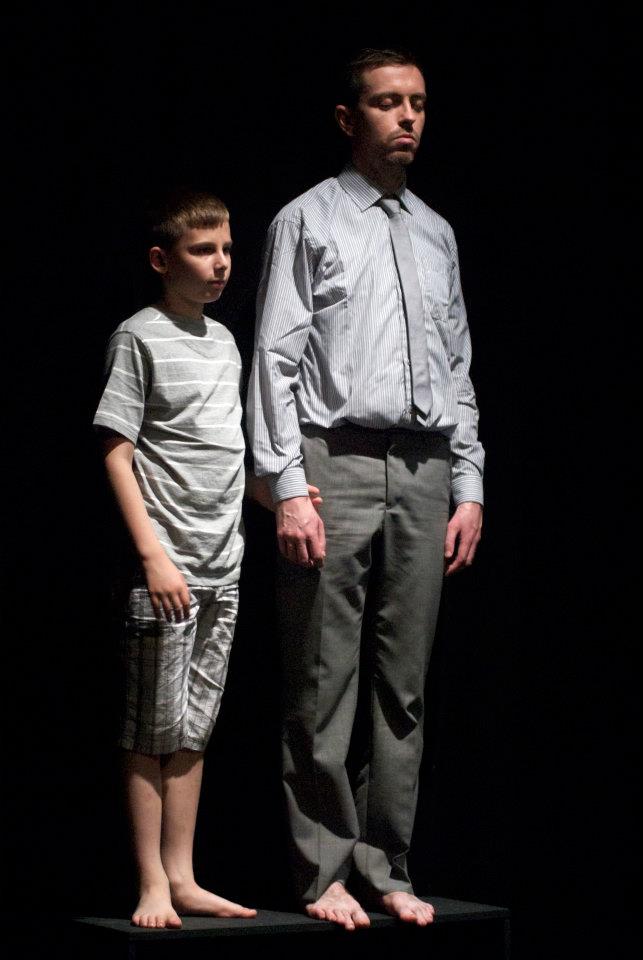 a man and a boy are standing next to each other on a stage .