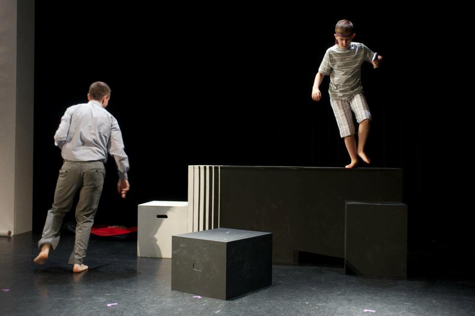 a man and a boy are standing on blocks on a stage