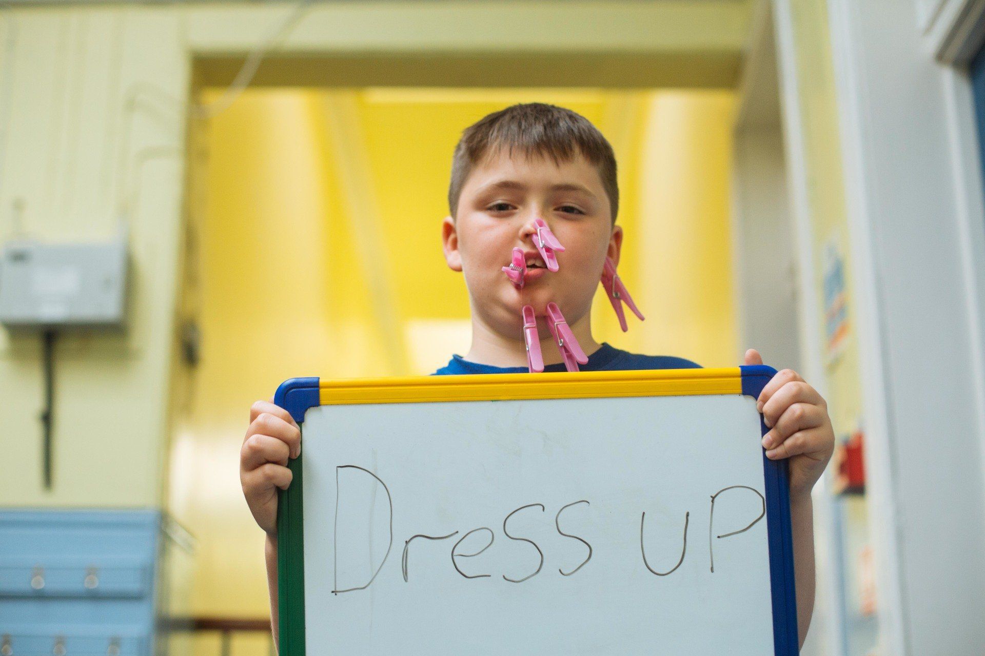 a young boy is holding a sign that says dress up