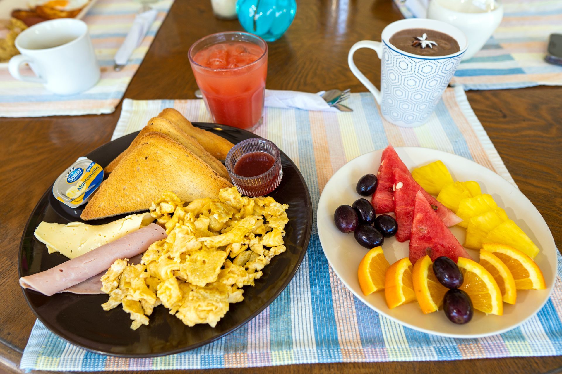 Desayuno: huevos revueltos, tostadas, fruta, zumo y café.