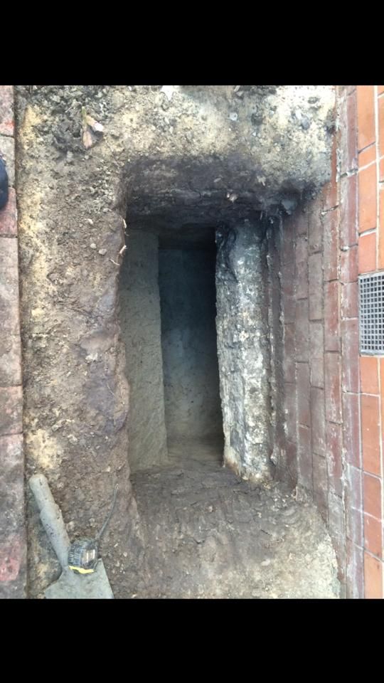 A Hole in the Ground Next to a Brick Wall — Melbourne, VIC — Special Reblocking Services