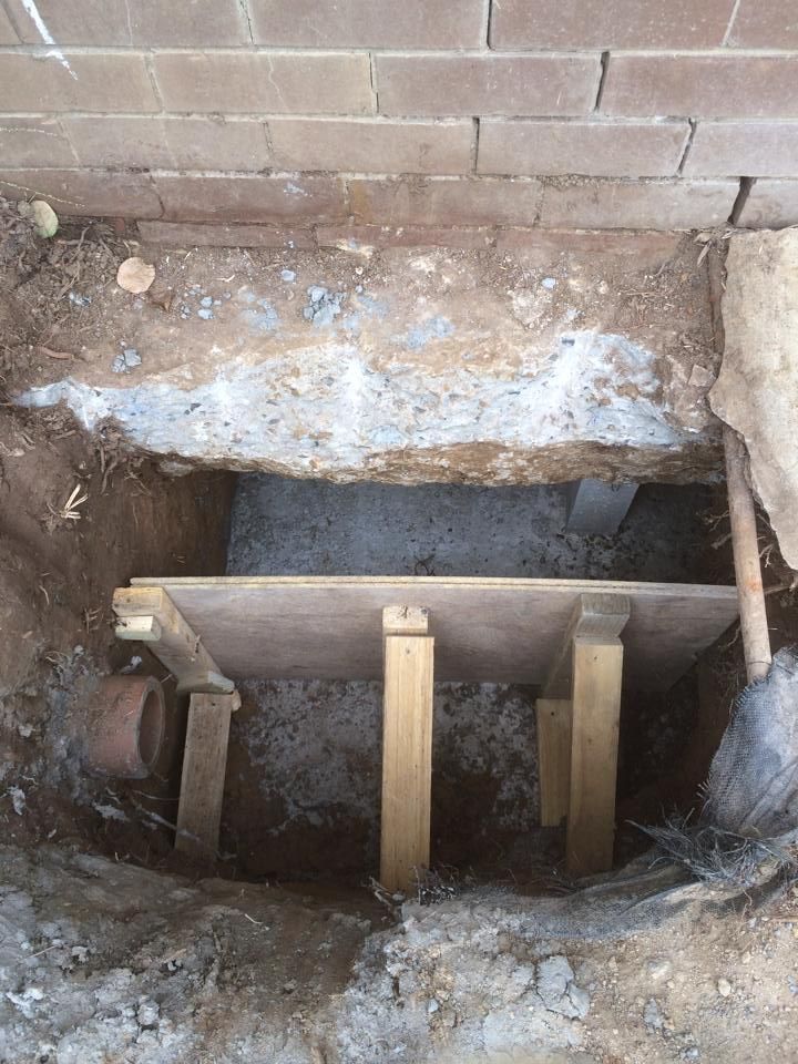 A Hole in the Ground With Wooden Blocks in It — Melbourne, VIC — Special Reblocking Services