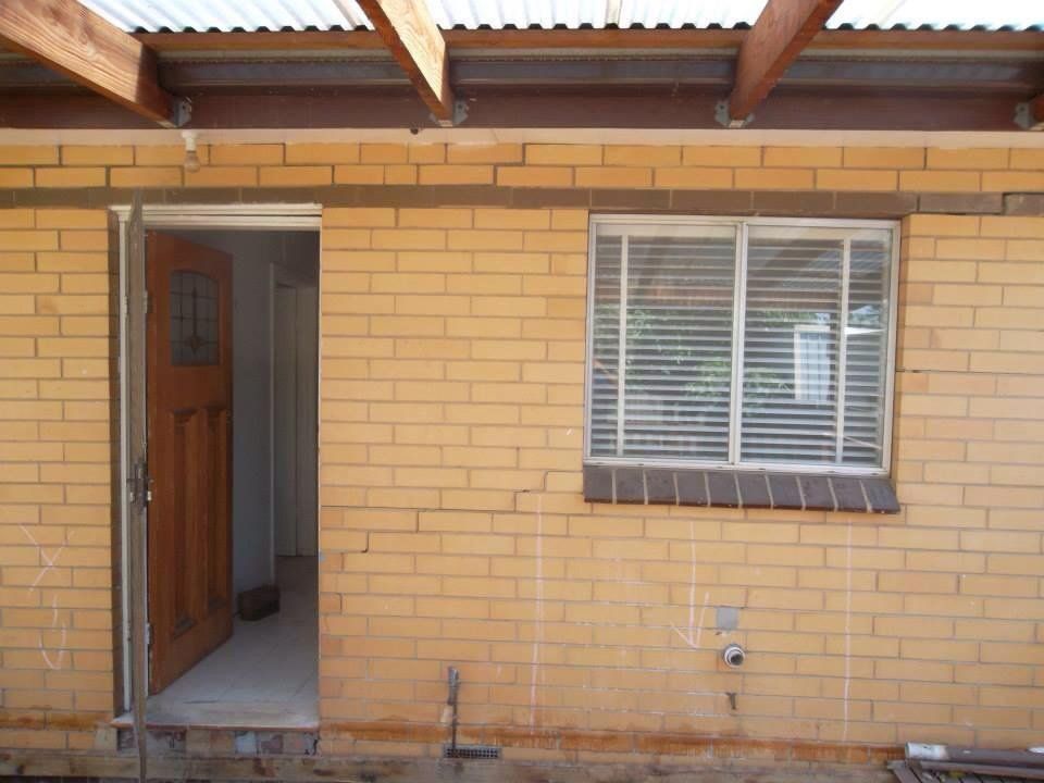 A Brick Building With a Window and a Door — Melbourne, VIC — Special Reblocking Services