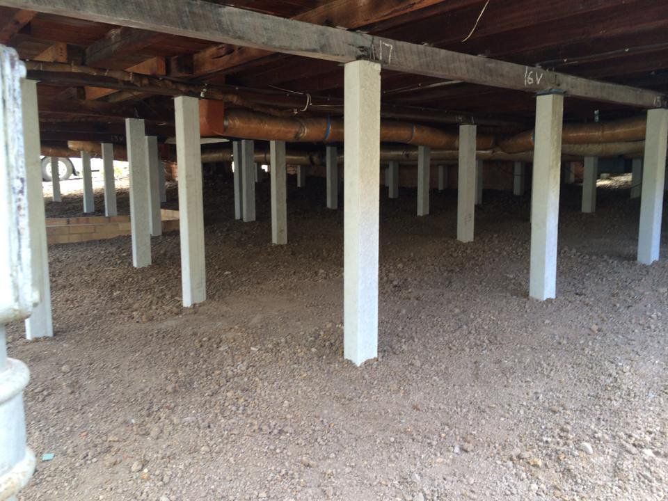 The Underside of a House With a Lot of Pillars and Pipes — Melbourne, VIC — Special Reblocking Services