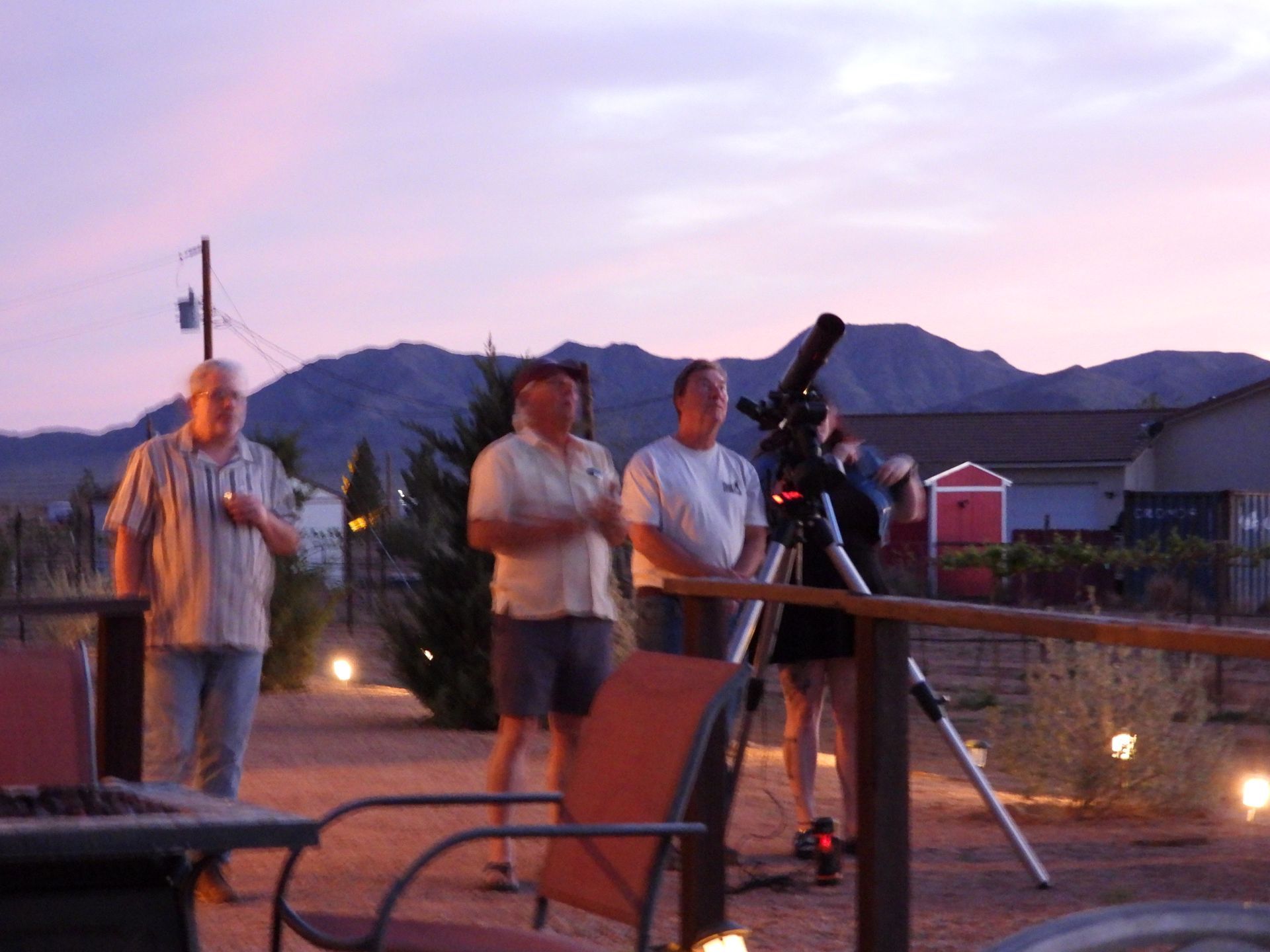 People looking at night sky with mountains in background.