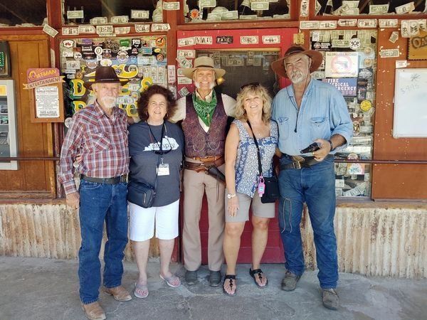 A group of people posing for a picture in front of a store