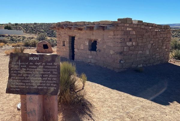 A stone building with a sign in front of it that says ropi