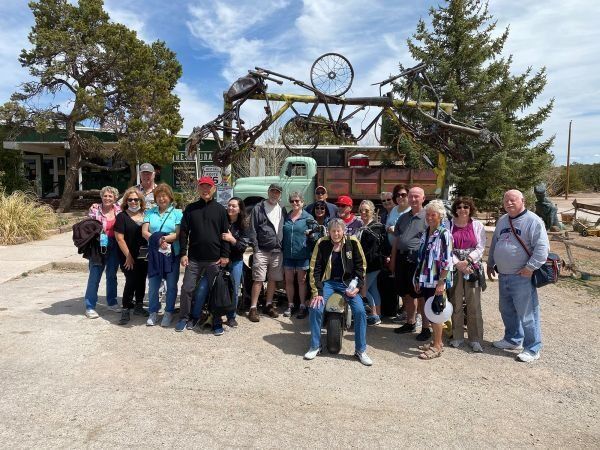 A group of people are posing for a picture in front of a truck.