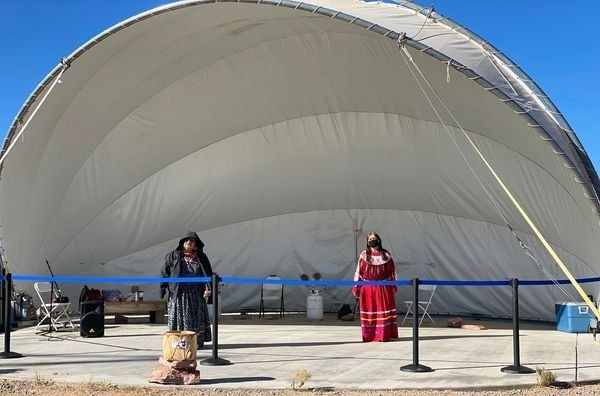 Two people standing in front of a large white tent