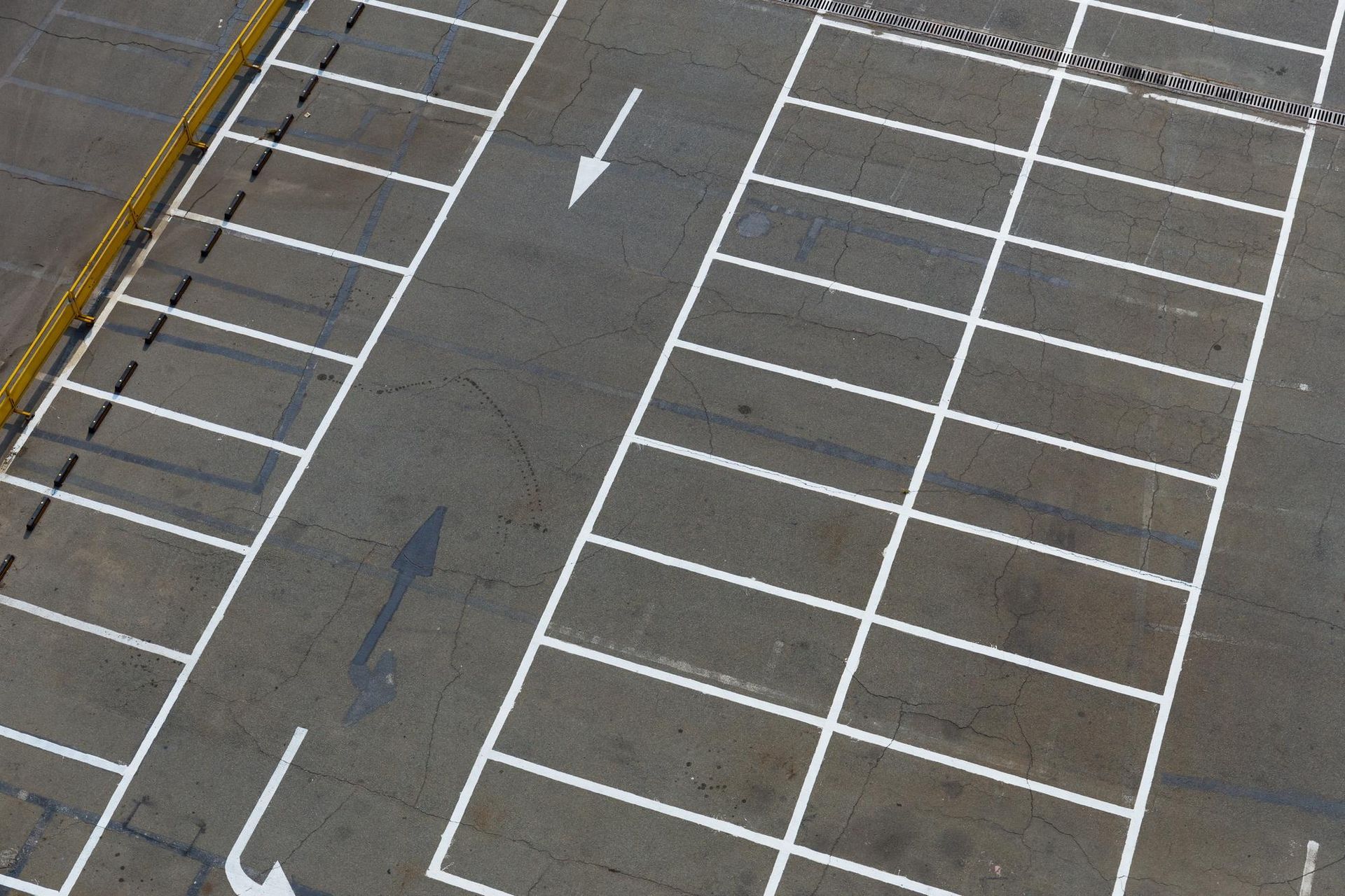 A parking lot with white lines and an arrow pointing to the right