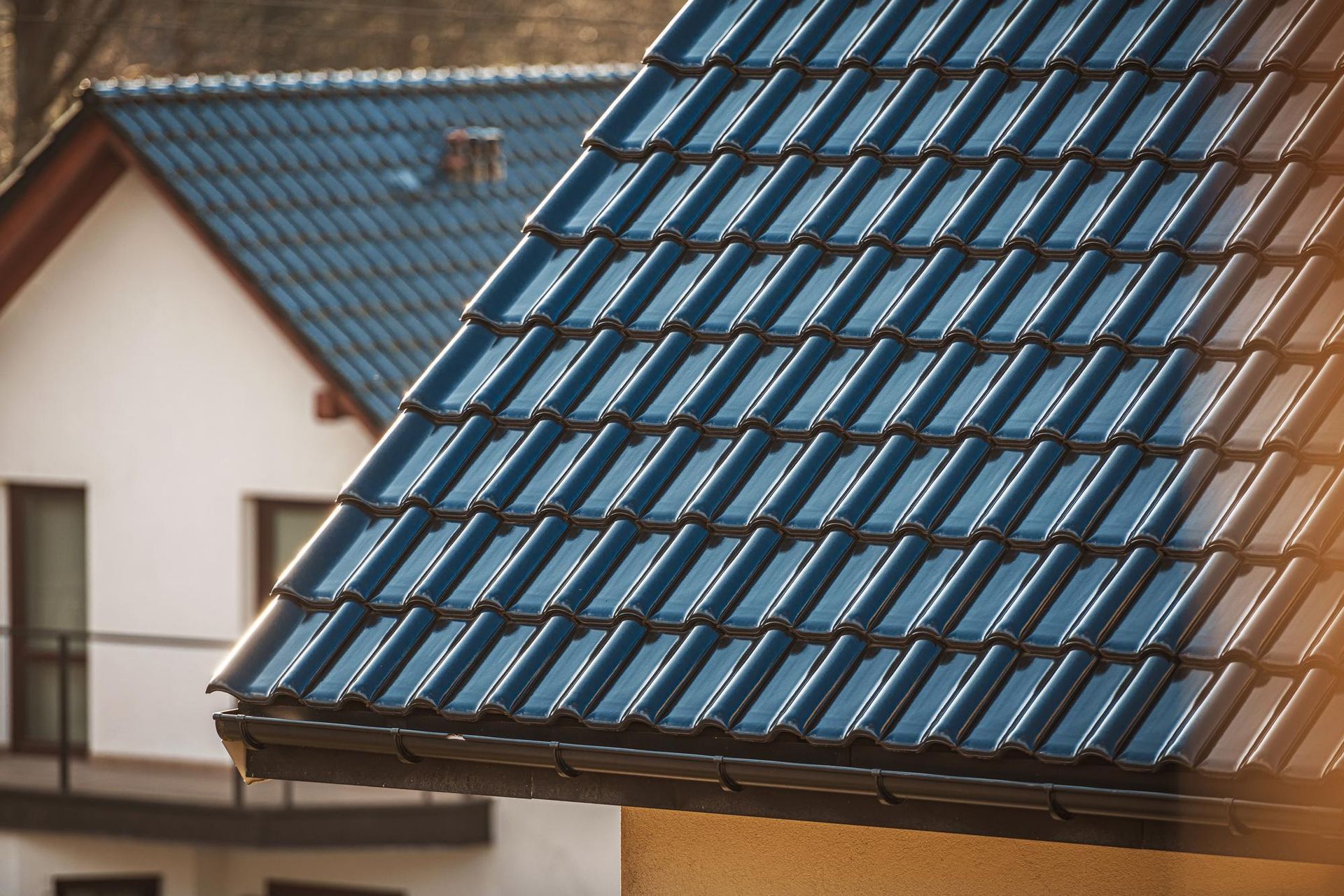 A close up of a blue tiled roof on a house.
