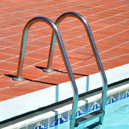A stainless steel staircase leading to a swimming pool